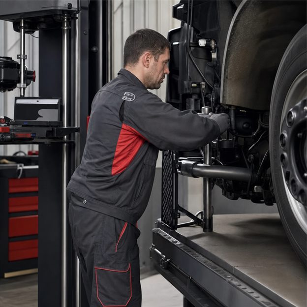 Mechaniker führt eine Achsvermessung in der Werkstatt durch